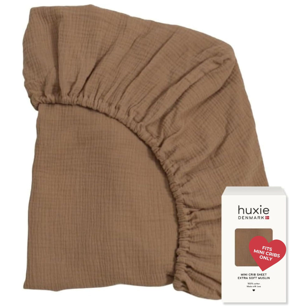 Huxie mini crib sheet folded, showcasing soft organic cotton for cozy naps