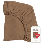 Huxie mini crib sheet folded, showcasing soft organic cotton for cozy naps