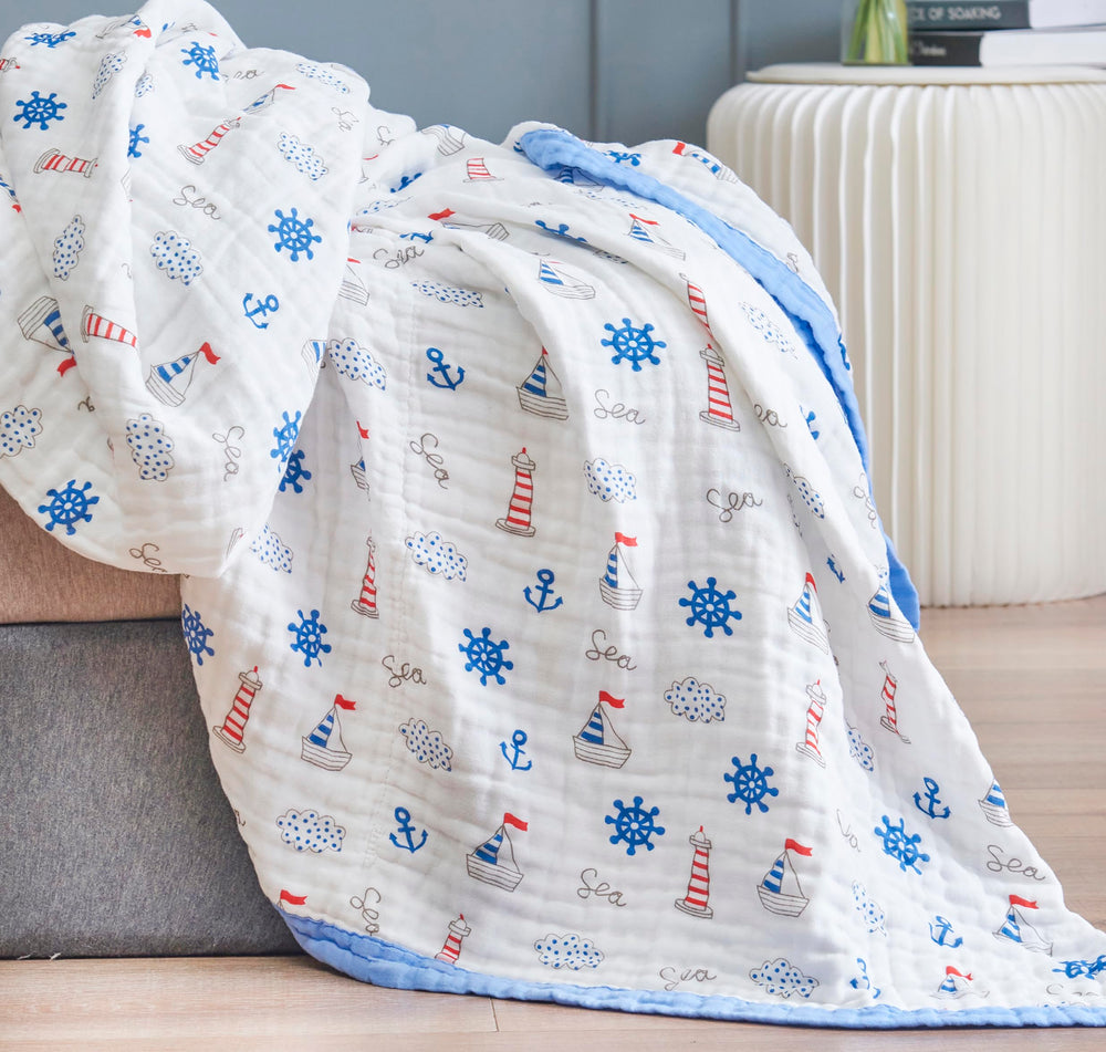 J-pinno Sailboat Sea Adventure blanket on a bed showing reversible design and soft warmth