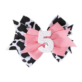 Jissoo cow print bow headband in pink, lightweight accessory for baby’s birthday outfit.