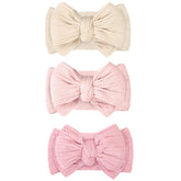 JOYOYO beige double-bow headband keeps hair away from the face during playtime.