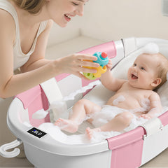 JoyYum collapsible baby bathtub in pink open and ready for use with cushion.