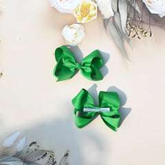 juccpul baby girl wearing green bow in a braid