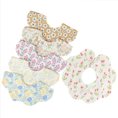 JUVA baby bib with flower pattern showing 360-degree rotation for all-around drool coverage