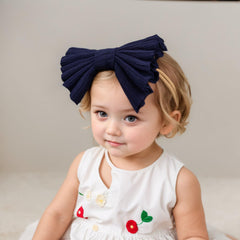Kenjudess dark-blue bow headband on a newborn showcasing versatile wear.