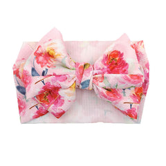 KIDOCHEESE Big Bows on a baby headband demonstrates gentle elastic fit.