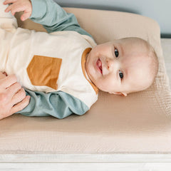 Konssy changing pad cover elasticized edge image emphasizes secure fit and slip prevention.