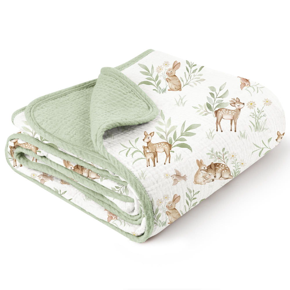 Konssy muslin blanket woodland pattern on crib for cozy nursery decor.