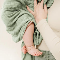 Konssy muslin swaddle blankets used as nursing cover in woodland-sage colorway.