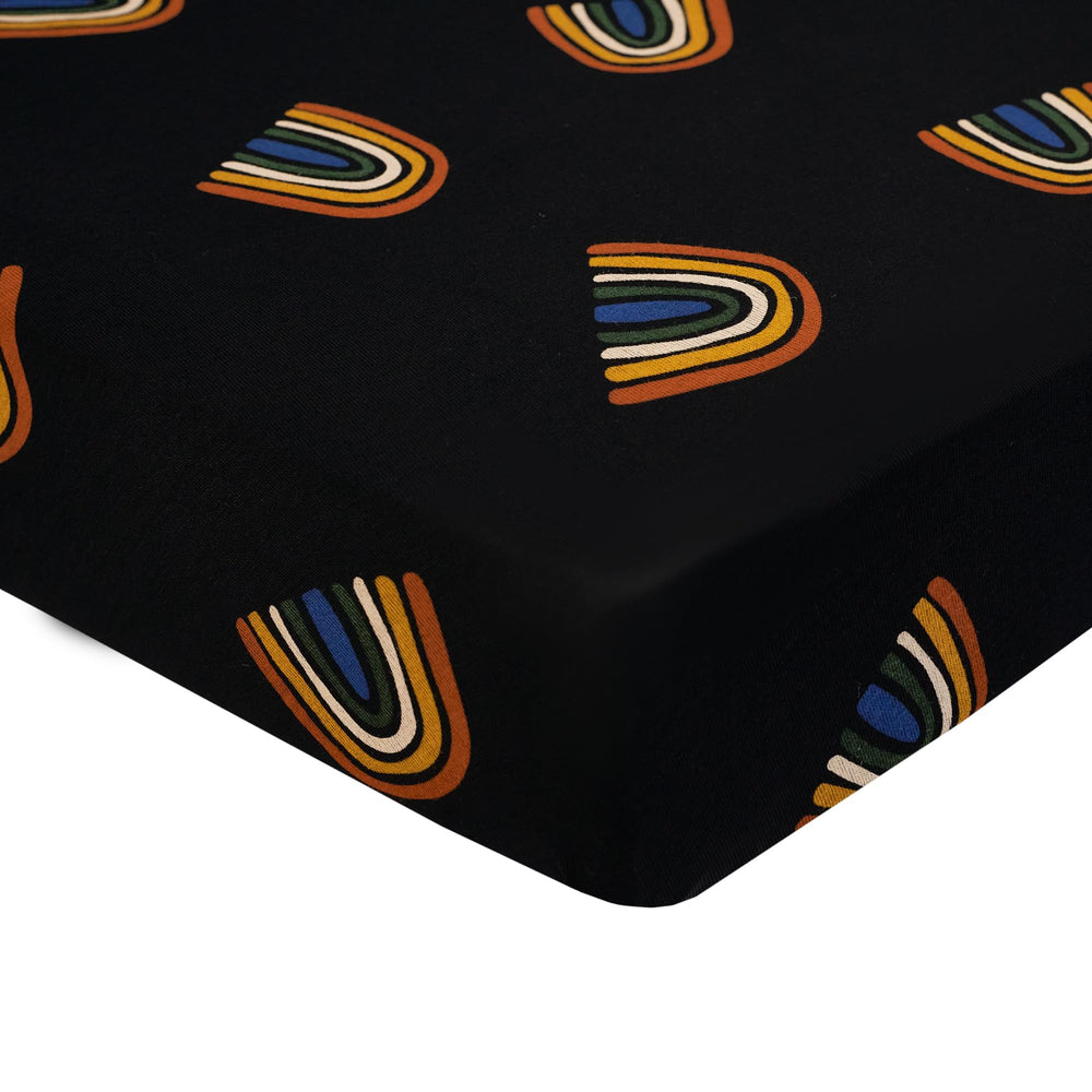 Kyte Baby crib sheet Rust Rainbow on Midnight close-up highlighting ultra-soft breathable bamboo rayon texture for gentle baby sleep.