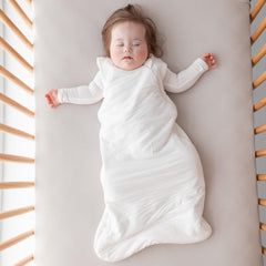 Kyte Baby soft crib sheet oat stretched-fit on mattress demonstrates snug, secure coverage