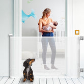 Kyxain retractable gate extended on stairs keeps kids and pets safe.