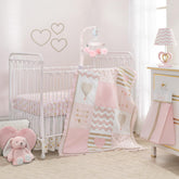 Lambs & Ivy Baby Love pink-gold comforter enhances cozy crib time.