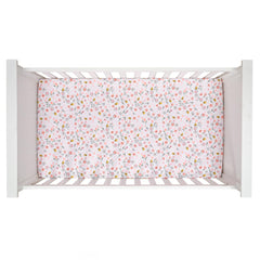 Lambs and Ivy Little Garden Sheet close-up, cotton fabric shows pastel pink flowers and delicate texture.