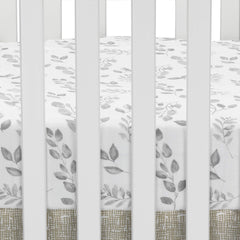 Close-up of elastic edge on Lambs & Ivy Painted Forest crib sheet for a secure fit.
