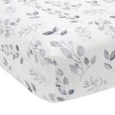 Lambs & Ivy Painted Forest crib sheet features gray watercolor leaves for a soft, coordinated nursery.