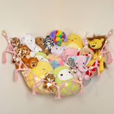 Lilly's Love macrame hammock in light pink provides decorative storage for plush toys.