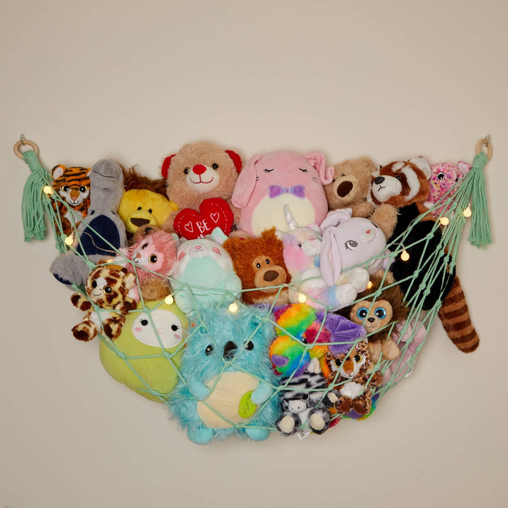 Lilly's Love macrame hammock mounted on mint flat wall for clutter-free playroom storage.