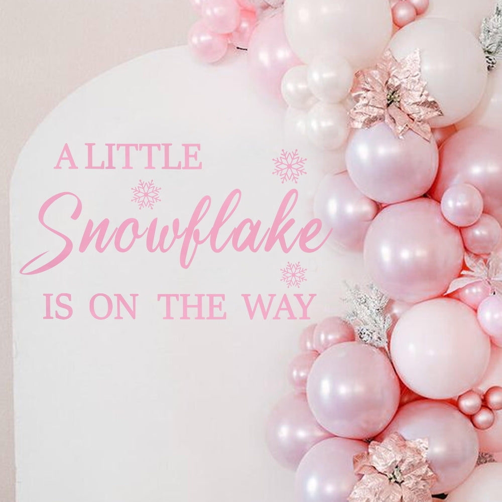 LINLULU A Little Snowflake Is On The Way decal creates a festive backdrop for memorable baby shower photos.