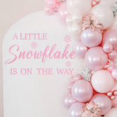 LINLULU A Little Snowflake Is On The Way decal creates a festive backdrop for memorable baby shower photos.