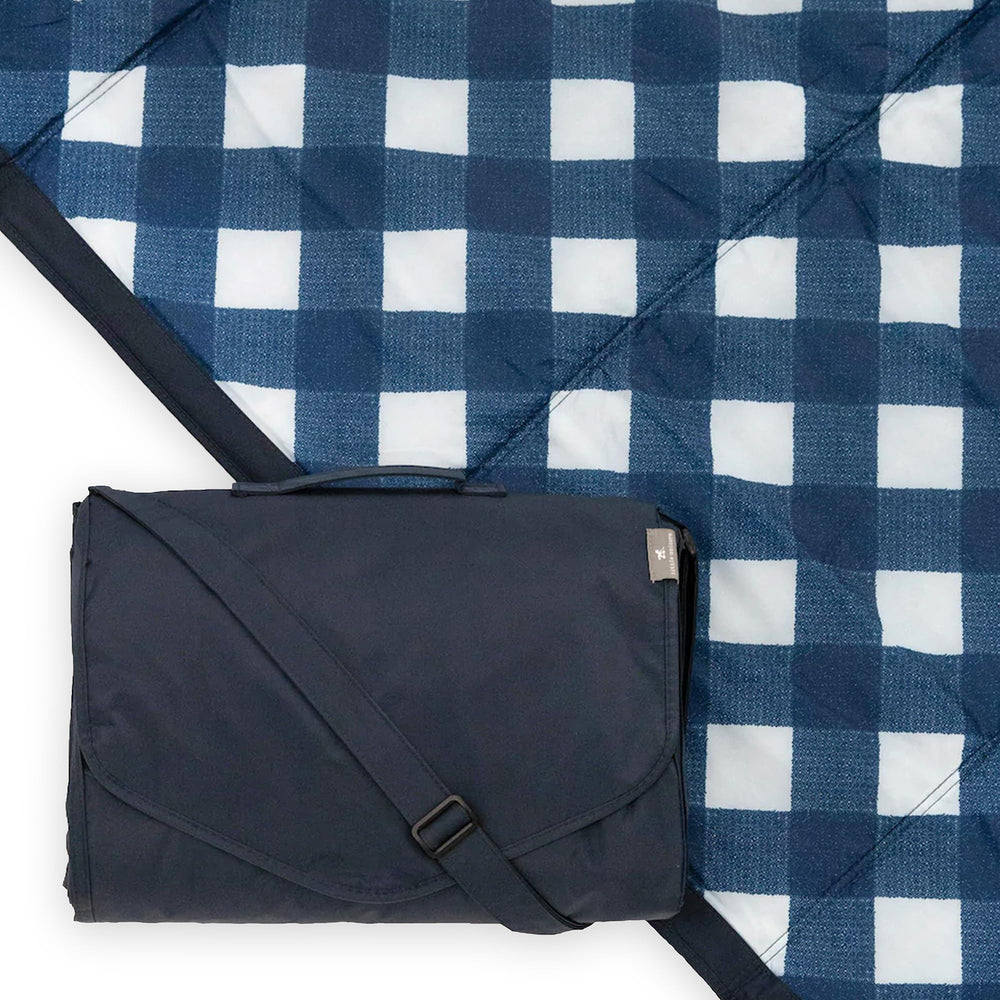 Little Unicorn 5x5 outdoor blanket opens to navy plaid and spreads quickly for family picnics.