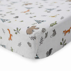 Little Unicorn Forest Friends crib sheet on mattress displaying breathable muslin comfort.