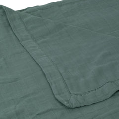 Little Unicorn Deluxe Muslin Quilt draped over toddler for versatile bedtime wrap and play mat.