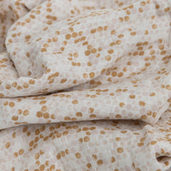 Little Unicorn Garden Bees swaddle on baby β secure wrap encouraging calm sleep.