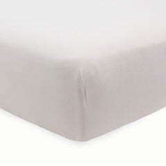 Little Unicorn Pebble stretch knit crib sheet on mattress highlighting soft viscose texture.