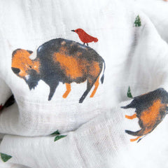 Little Unicorn premium cotton swaddle blanket baby swaddling scene in bison color soothing newborns.
