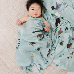 Loulou Lollipop world-map swaddle folded on crib demonstrates easy, roomy 47x47 coverage.
