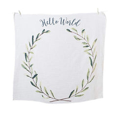 Lulujo Hello World laurel wreath design blanket serves as an elegant photo backdrop.