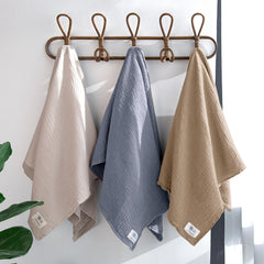 Lulumoon baby swaddled in grey blanket showing snug, womb-like embrace.