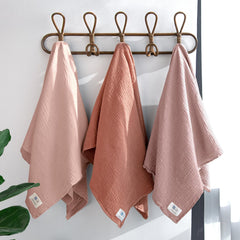 lulumoon Muslin Swaddle Chestnut baby-wrapped demonstrates secure wrap for soothing newborn sleep