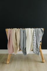 Mebie Baby muslin quilt dusty rose draped in nursery for versatile swaddling and cozy coverage.