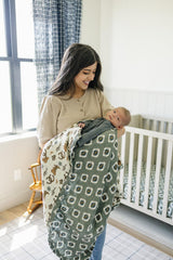 Mebie Baby muslin quilt displayed in a gender-neutral nursery setup.