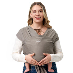 Momcozy baby wrap in brown worn by parent, enabling hands-free mobility with a snug fit.