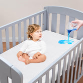 Moonsea crib mattress protector showing waterproof top layer for spill protection during naps