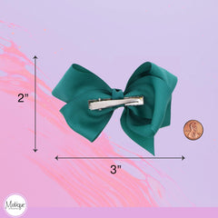 Motique close-up shows durable grosgrain texture on a dark turquoise bow.