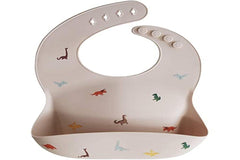 Mushie dinosaurs bib waterproof surface indicates spill-proof mealtime protection.