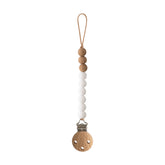 Mushie Eva pacifier clip with white beads keeps pacifier secure on the go