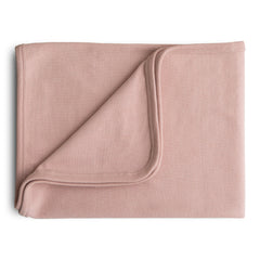 Mushie extra soft baby blanket folded in blush for cozy snuggles