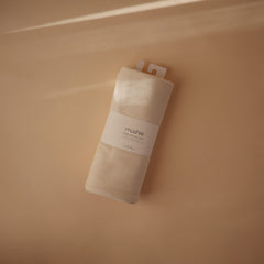 Mushie ribbed blanket Ivory swaddle setup highlighting easy wrapping and secure comfort.