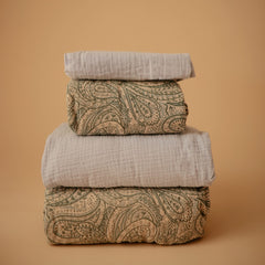 Mushie baby blue fitted sheet shows elastic edge for easy removal and secure fit.