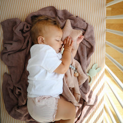 Mushie fitted crib sheet elastic edge demonstrates easy removal and quick wash