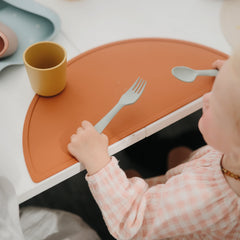 Mushie flatware set for kids dining in Sage facilitates calm, coordinated mealtime.