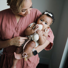 Mushie Hera pacifier clip eight inch length for easy reach.