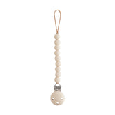 Mushie Hera pacifier clip shifting sand closeup shows safe silicone beads for soothing on the go.