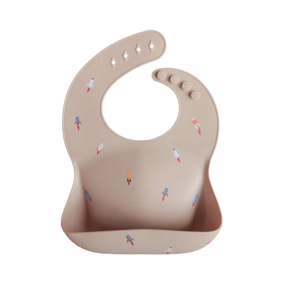 Mushie rocket ship bib closeup highlights built-in pocket for mess containment