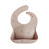 Mushie rocket ship bib closeup highlights built-in pocket for mess containment